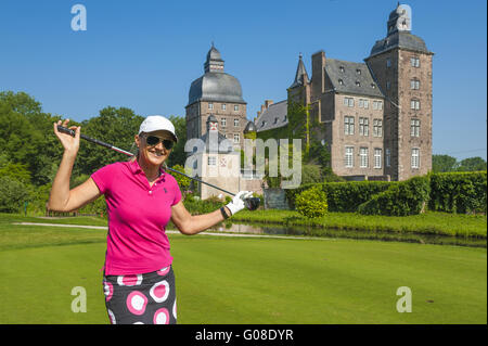 Golfer stands on the golf course in front of castl Stock Photo