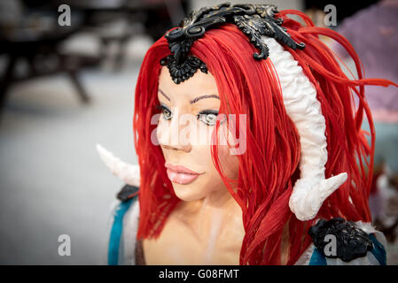 Red hair haired woman with white horns edible at Cake International – The Sugarcraft, Cake Decorating and Baking Show in London Stock Photo