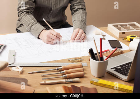 Professional architect and construction engineer working at office desk hands close-up, he is drawing on a building draft with a Stock Photo