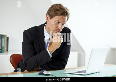 Concerned Businessman in front of laptop Stock Photo