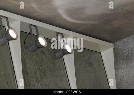 industrial lights on the wall inside a building Stock Photo