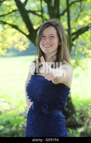 pretty teenage girl with lovely curly long hair giving a thumbs up Stock Photo