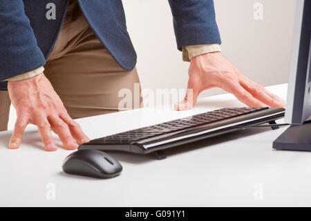 Man Standing and Looking At A Computer Monitor Stock Photo