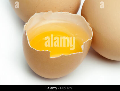 Tree whole eggs and another broken in half raw egg Stock Photo