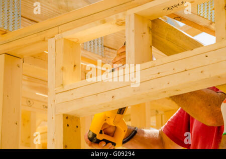 Building contractor worker using a reciprocating saw to cut Stock Photo