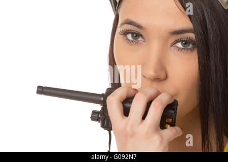 serious female construction worker talking with a walkie talkie Stock Photo