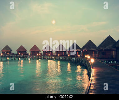 houses on piles on water at night in  fool moon li Stock Photo