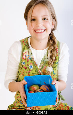 Young girl presenting a box with painted eggs Stock Photo