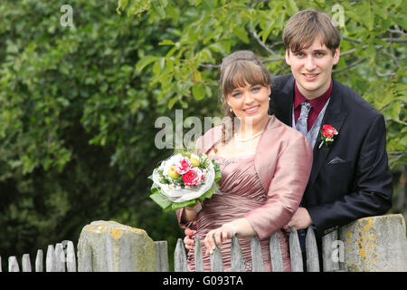 Bride and groom in autumn at wooden garden gate Stock Photo
