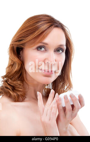 beautiful adult woman applying cream on face. Stock Photo