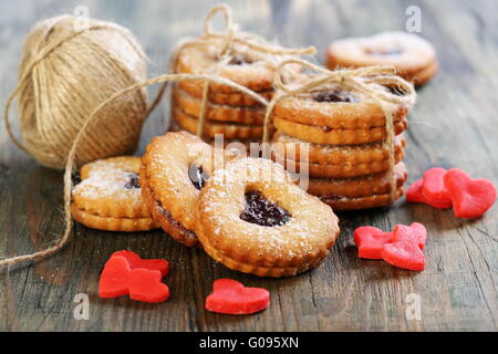 Red marzipan hearts, cookies and ball of twine. Stock Photo