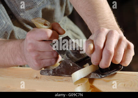 Carpenter working with a planer in his workshop Stock Photo
