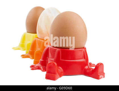 Two whole boiled egg and one onyx egg in egg cup, isolated on white Stock Photo