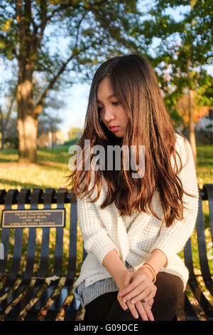 Woman sitting on bench Stock Photo