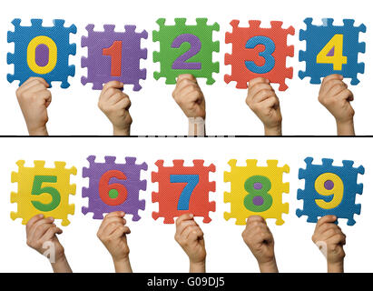 Children hands holding numbers. White isolated multicolor numbers Stock Photo