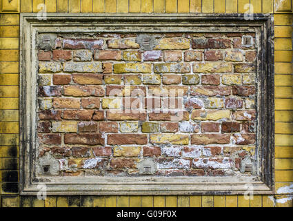 Old brick wall pattern closeup with stucco frame Stock Photo