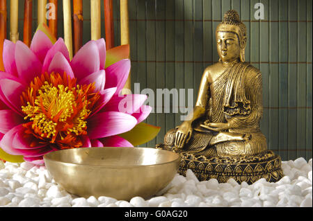 Buddha sitting in meditation with singing bowl Stock Photo