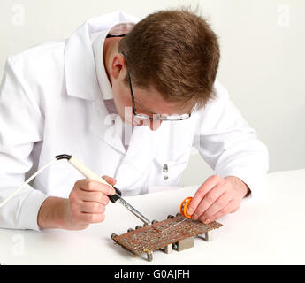 working electronics repairing board using soldering pen Stock Photo