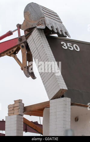 wreck excavator at work demolishing a building wall Stock Photo