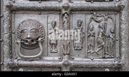 Door knocker and bas-relief of ancient bronze gate Stock Photo