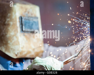 Arc welder worker in protective mask welding metal Stock Photo