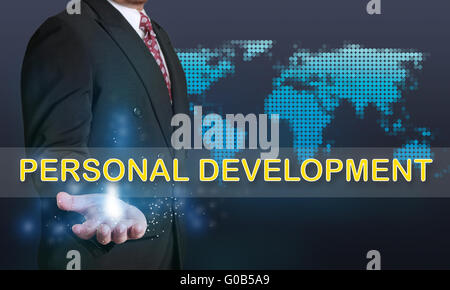 Business concept image of a businessman showing Personal Development words on his hand over blue background with dotted world ma Stock Photo