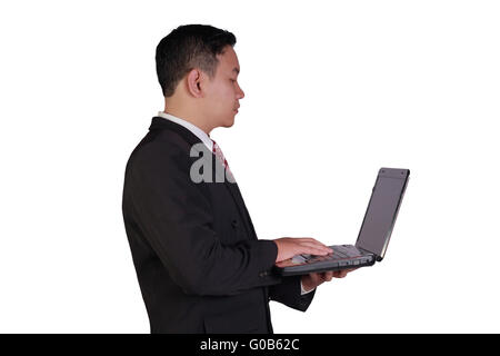 Business concept image of an Asian businessman holding laptop with one hand and typing with the other hand isolated on white Stock Photo