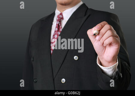 Business concept editable image of a businessman holding marker in writing position on empty screen in front of him Stock Photo