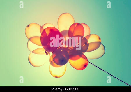 Vintage photo of colorful balloons on blue sky. Concept of love in summer, valentine, wedding and honeymoon Stock Photo