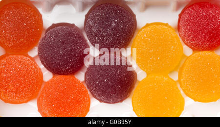 Round jelly sprinkled with sugar in a plastic box. Stock Photo