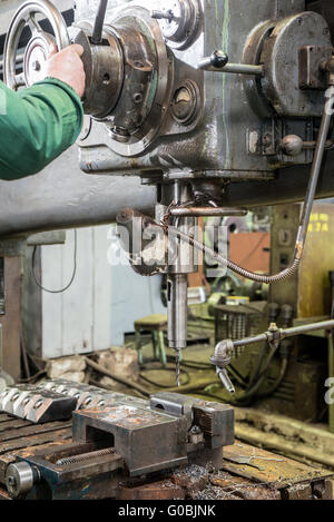 machinist working on industrial drilling machine in workshop Stock Photo