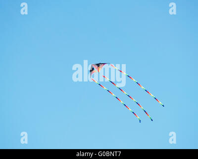 Multi-colored kit flying in a clear blue sky Stock Photo