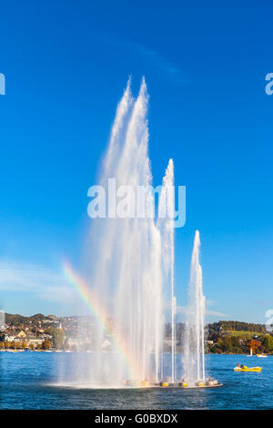 Beautiful view of the fountain at  Mythenquai with rainbow in the Zurich lake at sunset, Switzerland Stock Photo