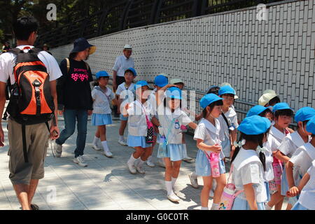 School children group walking in a park together with their educators. Stock Photo