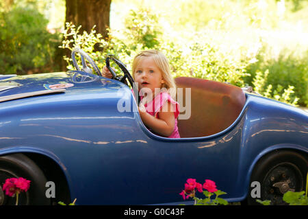 little girl in a fun fair drive car Stock Photo