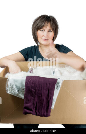 satisfied woman has cardboardbox with clothes on h Stock Photo