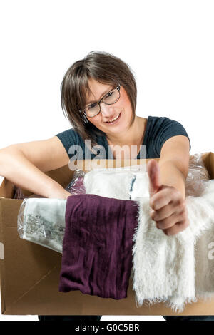 happy woman has cardboardbox with clothes on her k Stock Photo