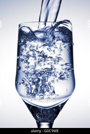 Water is being poured into a glass Stock Photo