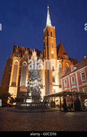 Church of the Holy Cross and St Bartholomew from 13th century at night in Wroclaw, Poland, statue, sculpture of John of Nepomuk Stock Photo