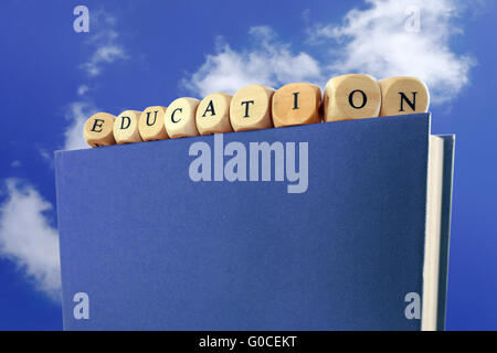 Education message written with wooden blocks on the top of a book Stock Photo