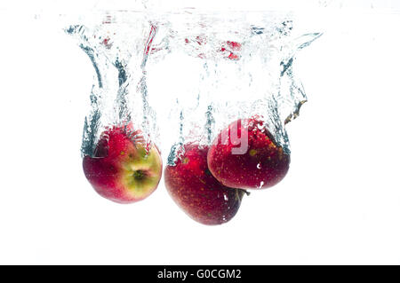 Apples fall deeply under water Stock Photo
