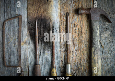 Hand Saw, Hammer and Screwdrivers on Rustic Wood Background Stock Photo