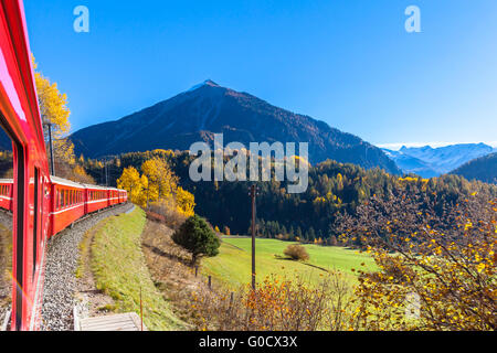 Travel with train of Rhaetian Railway in golden autumn through the line of Glacier Express in Engadin, Canton of Grisons, Switze Stock Photo