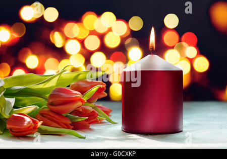 Romantic setting: red candle and tulips Stock Photo