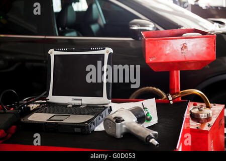 Diagnostic machine tools ready to be used with car in background. Stock Photo