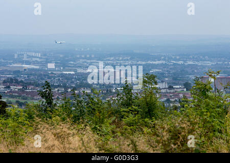 Aircraft coming into land at Glasgow Airport with view of Glasgow in background Stock Photo