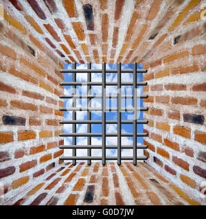 Prison's window and bars in wall from red brick wi Stock Photo