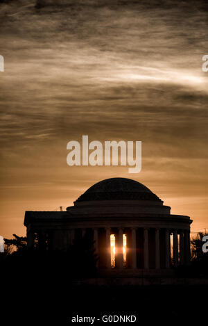 WASHINGTON, D.C., United States — The Jefferson Memorial is dramatically silhouetted against the rising sun over the Tidal Basin in Washington, D.C. This iconic view captures the neoclassical monument's distinctive dome and colonnade in stark contrast with the golden light of dawn. Stock Photo