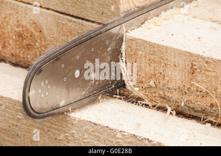 Chainsaw cutting wooden beam Stock Photo