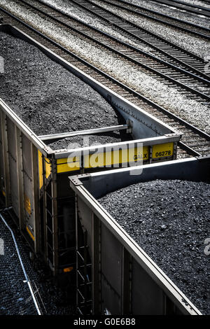 Overhead view of train cars piled high with black coal on railroad tracks along side Stock Photo